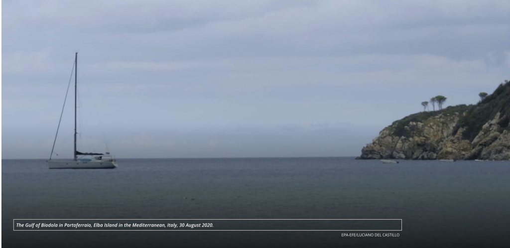 A large body of water with a small island in the distance.